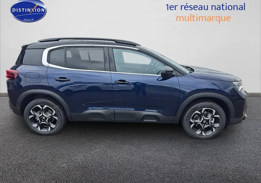 Profil droit d'un Citroën C5 Aircross Bleu Eclipse 2025 avec jantes alliage et barres de toit noires.
