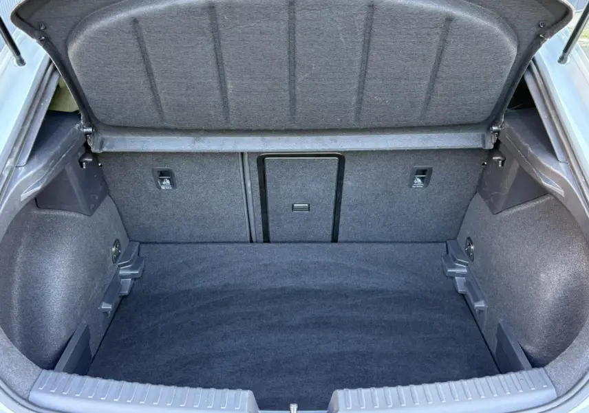 Vue intérieure du coffre ouvert de la CUPRA Leon 2025, montrant un espace de chargement propre et tapissé en tissu gris.