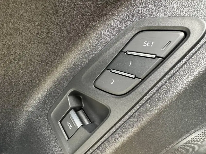 Détail des boutons de réglage mémoire des sièges et ouverture du coffre sur la porte côté conducteur de l'Audi Q3 noir Mythique.