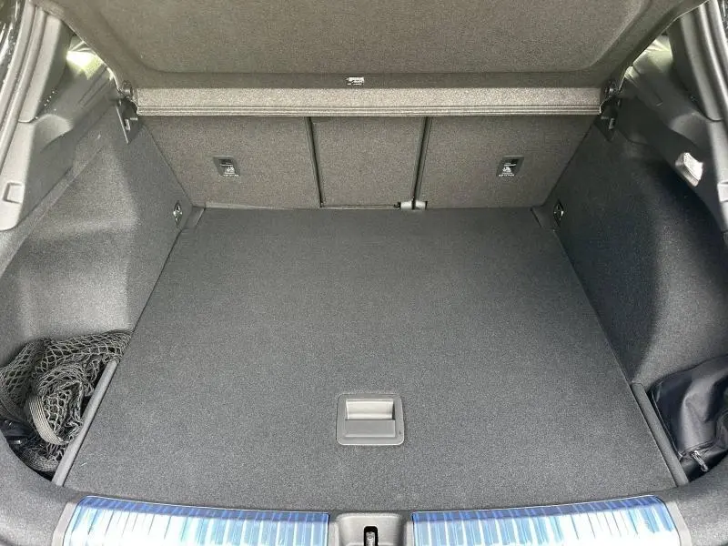 Coffre spacieux de l'Audi Q3 2.0 TDI 150ch S line 2026, vu de face, avec revêtement noir et filet de rangement.