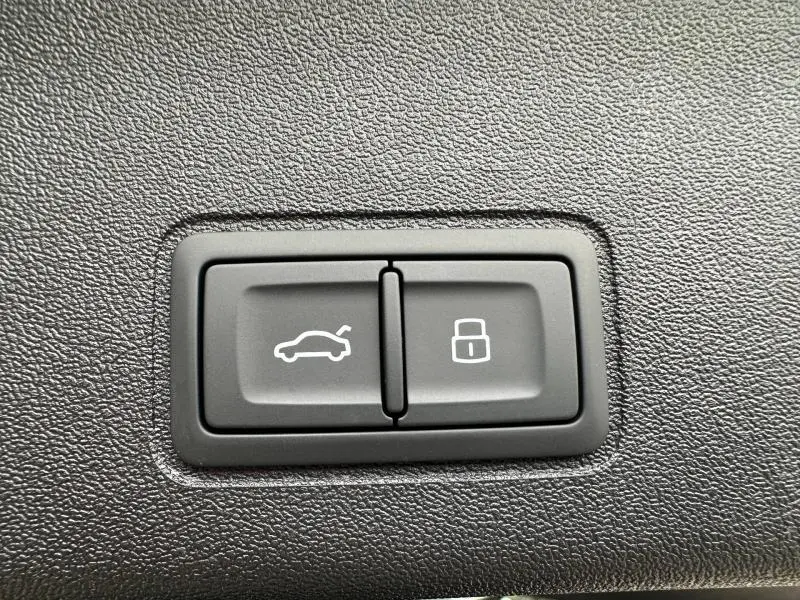 Boutons de commande du coffre électrique et du verrouillage centralisé sur tableau de bord noir d'Audi Q3 2.0 TDI 2026.