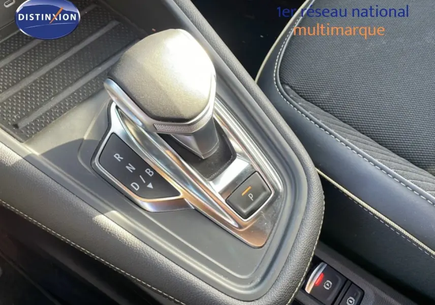 Gros plan sur la console centrale avec levier de vitesse automatique et siège tissu gris du Renault Symbioz 2025.