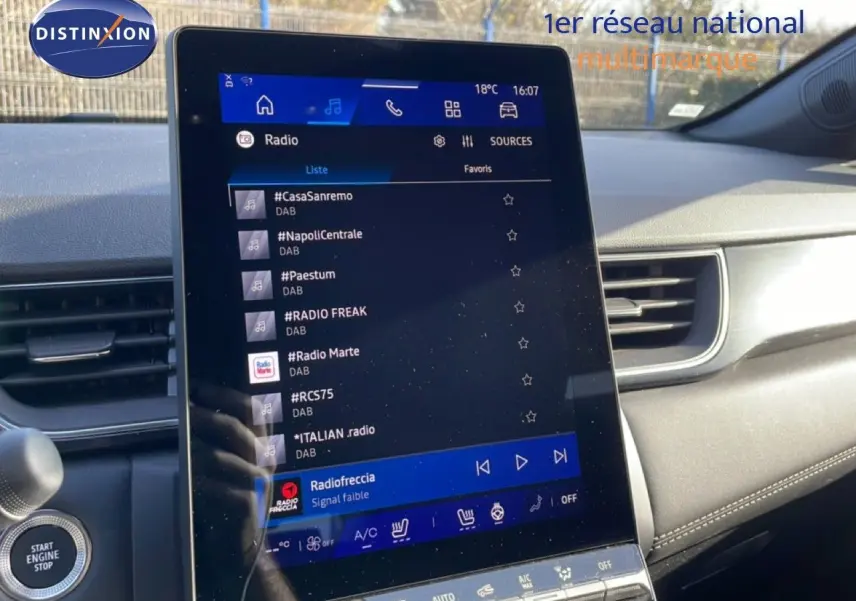 Écran tactile central affichant la radio dans l’habitacle d’une Renault Symbioz gris cassiopée métal, vue de face.