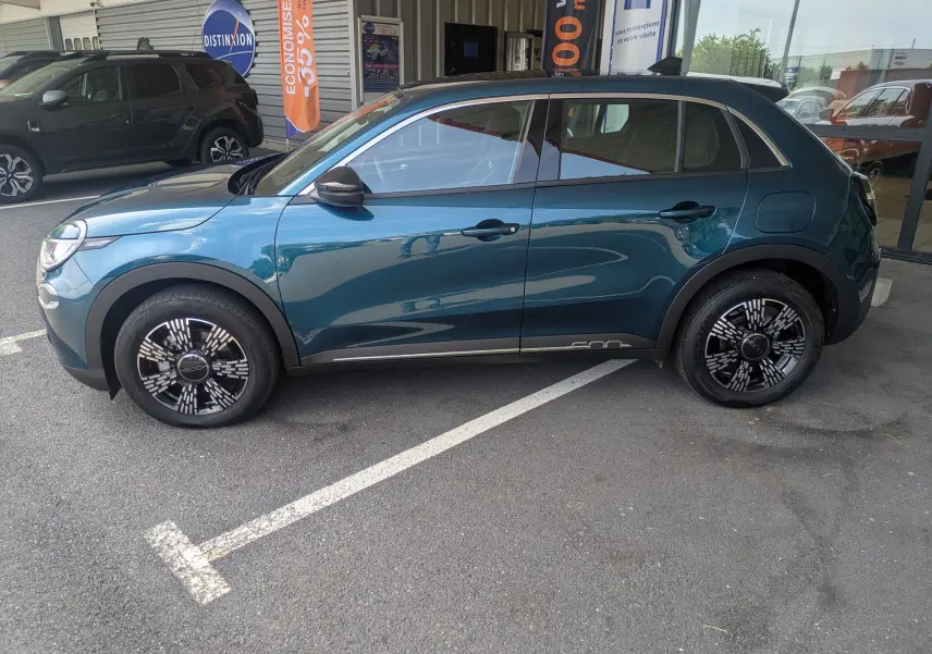 Vue de profil côté gauche d'une FIAT 600 1.2 Hybrid 2025 en bleu Sea of Italy avec jantes noires à motifs blancs.