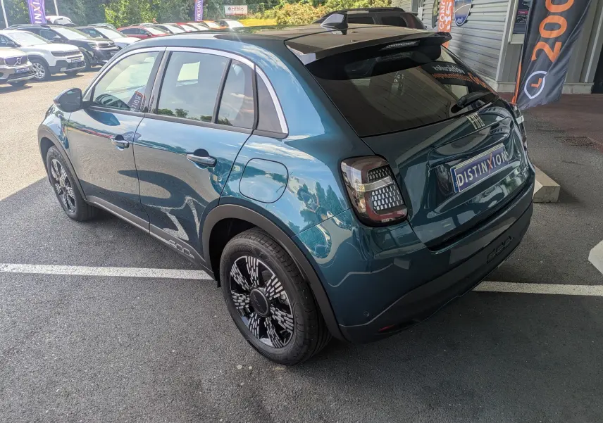 Vue 3/4 arrière droite d'une FIAT 600 1.2 Hybrid bleu Sea of Italy avec jantes noires et toit noir brillant.