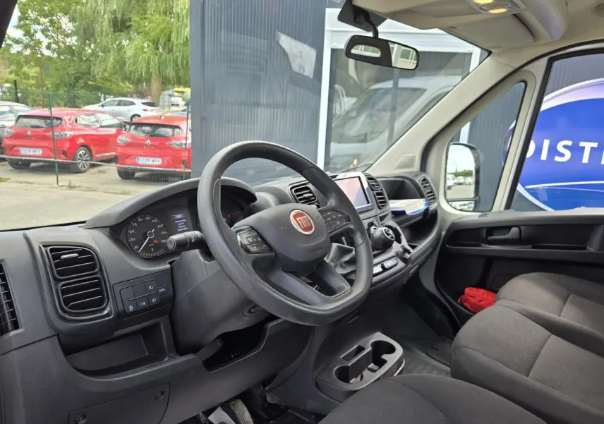 Vue intérieure côté conducteur du Fiat Ducato Fourgon 2022, volant noir avec tableau de bord et écran tactile central.