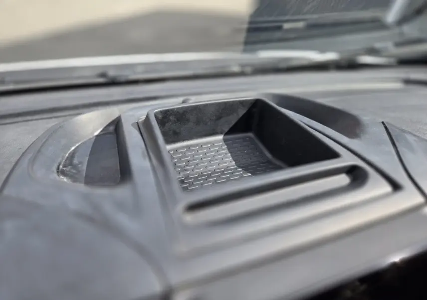 Gros plan sur le rangement central en plastique noir du tableau de bord du Fiat Ducato Fourgon blanc, intérieur lumineux.