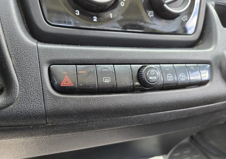 Gros plan sur la rangée de boutons de commande noirs du tableau de bord du Fiat Ducato Fourgon blanc, version 2022.