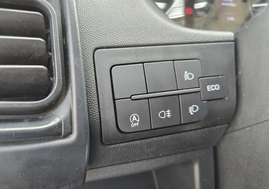 Gros plan sur les commandes d’éclairage et bouton ECO du tableau de bord du Fiat Ducato Fourgon blanc.