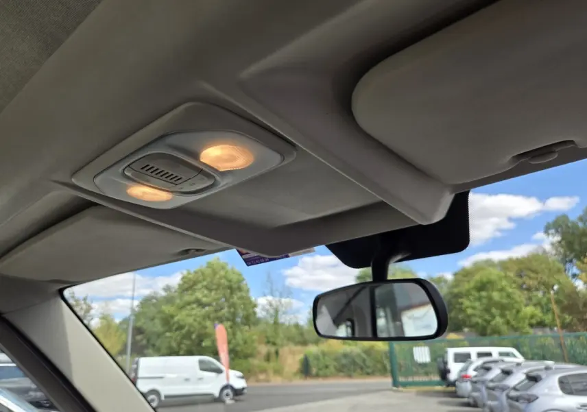 Vue intérieure du plafond et du rétroviseur central d’un FIAT Ducato Fourgon blanc visible à l’extérieur par la vitre avant.
