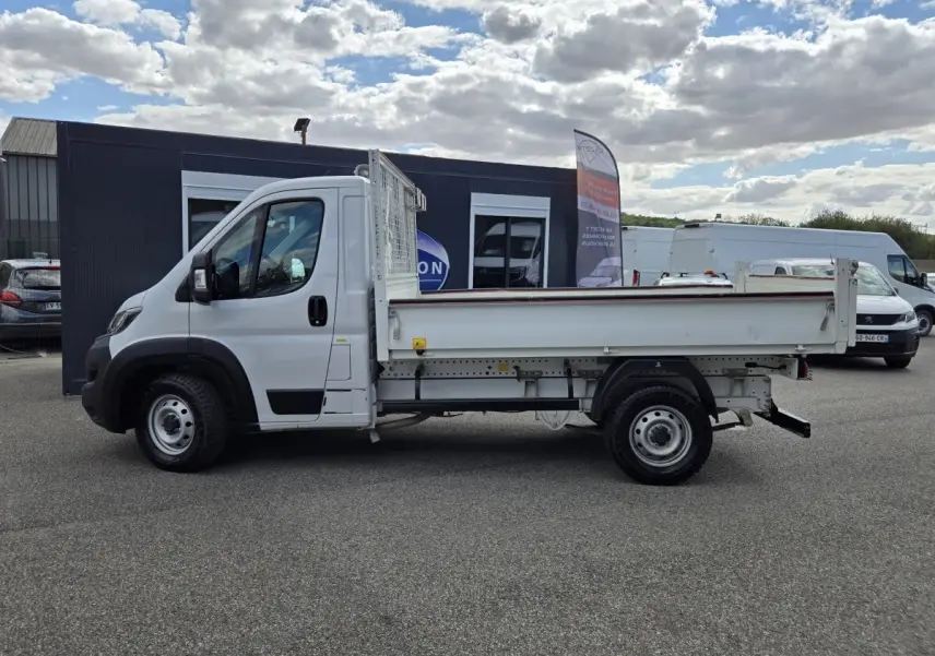 Vue latérale droite d’un FIAT Ducato Fourgon blanc 2022 avec benne plate et cabine simple, stationné en extérieur.