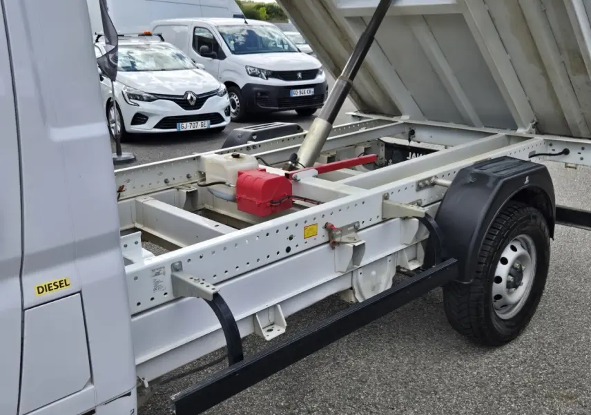 Vue latérale droite du FIAT Ducato Fourgon blanc 2022 avec benne relevée montrant le châssis et le système hydraulique.