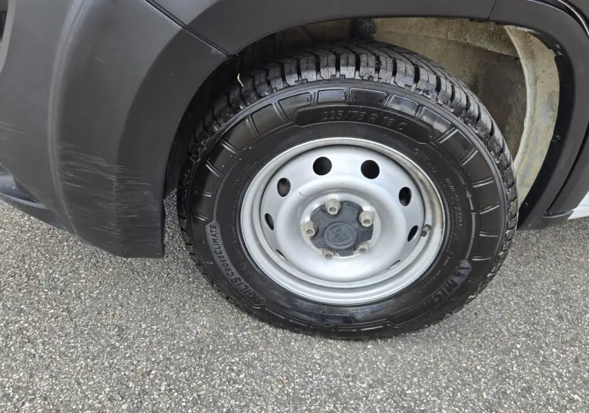 Gros plan sur la roue avant droite du Fiat Ducato Fourgon blanc, avec jante acier et pneu Michelin CrossClimate.
