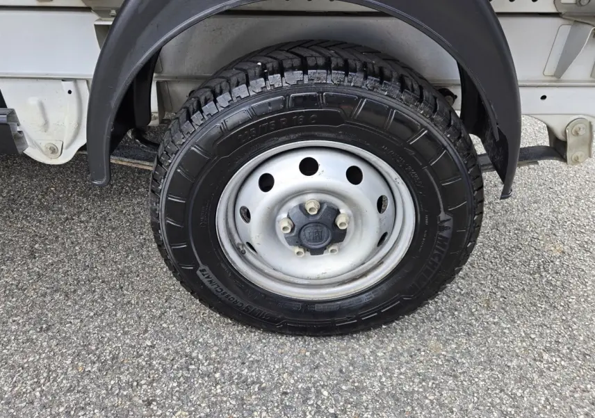 Gros plan sur la roue arrière droite du FIAT Ducato Fourgon blanc, montrant la jante acier et le pneu tout-terrain.