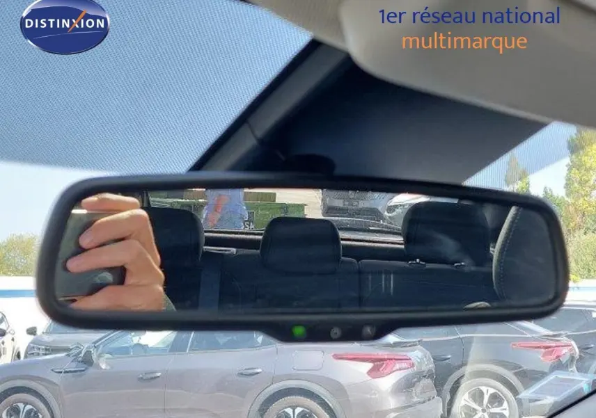 Vue latérale gauche d'un Nissan Qashqai blanc lunaire métal, avec jantes bi-ton 18 pouces visibles sur un parking.