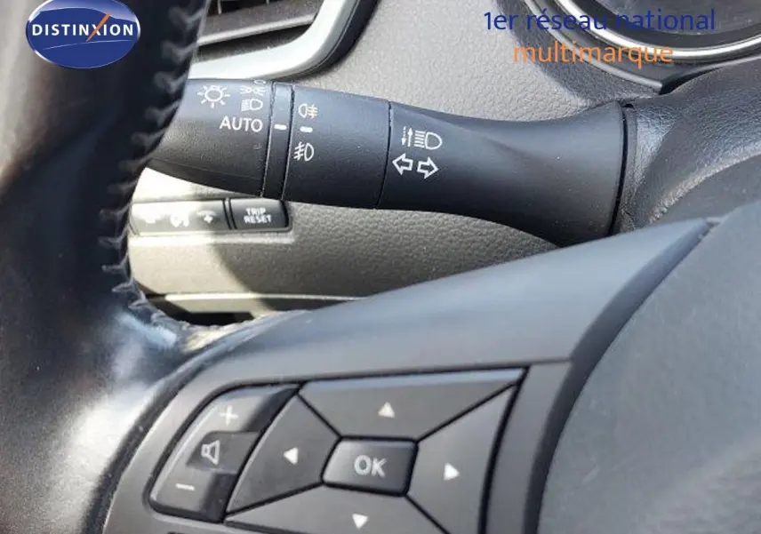 Gros plan sur les commandes au volant et le commodo d'éclairage du Nissan Qashqai blanc lunaire de 2019.