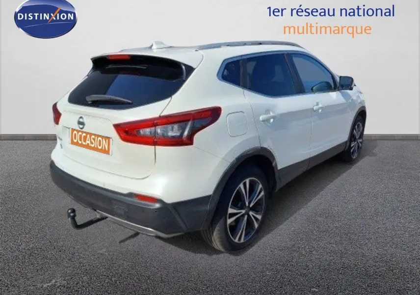 Vue 3/4 arrière droite du Nissan Qashqai blanc lunaire avec attelage et jantes bi-ton 18 pouces.