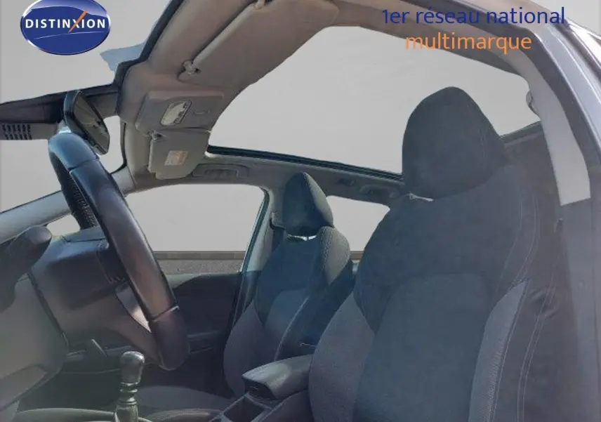 Vue intérieure côté gauche du Nissan Qashqai 2019 blanc lunaire avec sièges tissu gris et toit ouvrant panoramique.