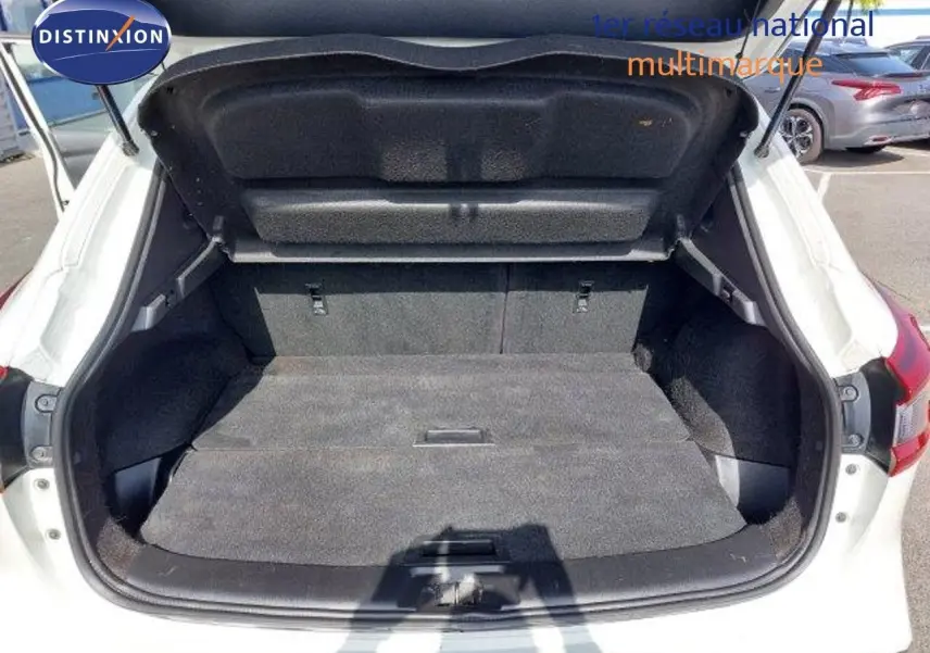 Coffre ouvert vue arrière d'un Nissan Qashqai blanc lunaire métal, montrant l'espace de chargement vide.