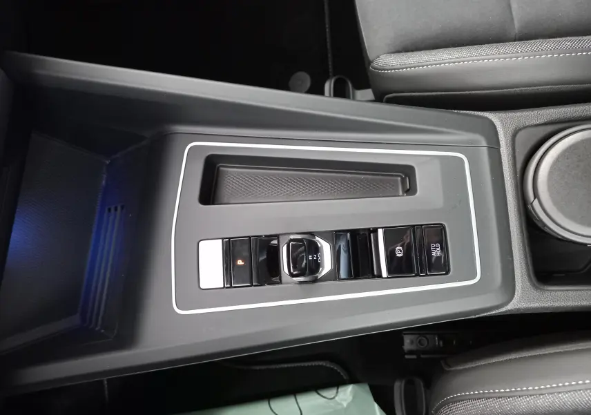 Vue rapprochée de la console centrale noire de la Volkswagen Golf 2.0 TDI 150 DSG7 Style avec levier de vitesse électronique.