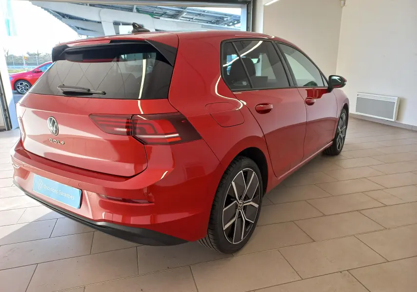 Vue 3/4 arrière droite d'une Volkswagen Golf 2.0 TDI 150 DSG7 Style rouge Roi avec jantes alliage 18 pouces dans un showroom.