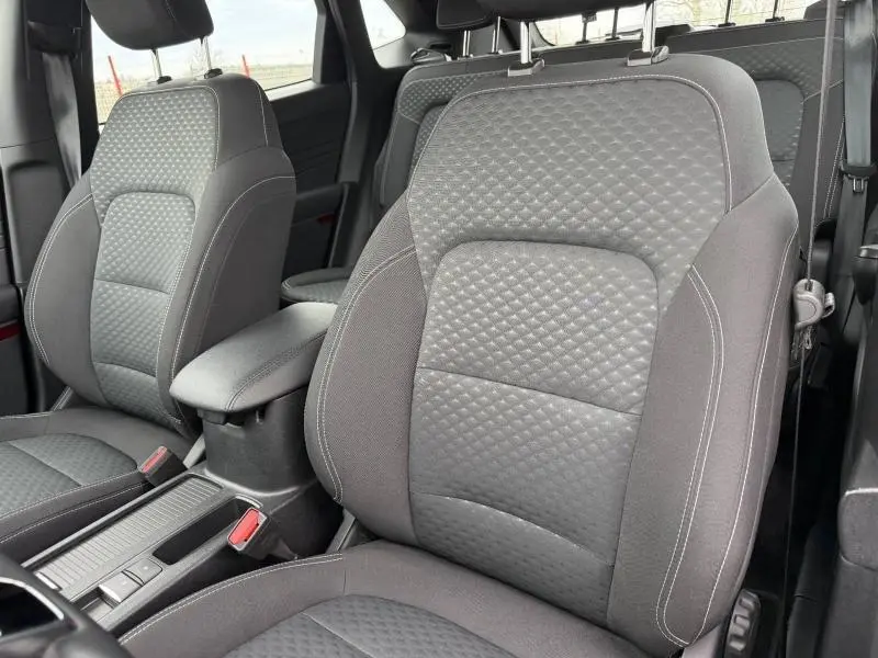 Gros plan sur les sièges avant gris à motifs du Ford Kuga 1.5 EcoBoost 150ch Titanium 2024, intérieur sobre et moderne.