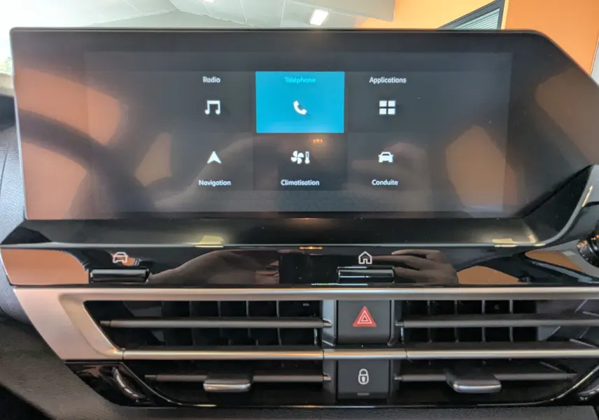 Écran tactile central de 10 pouces du Citroën C4 Hybrid 145 en gros plan, avec commandes de climatisation visibles.