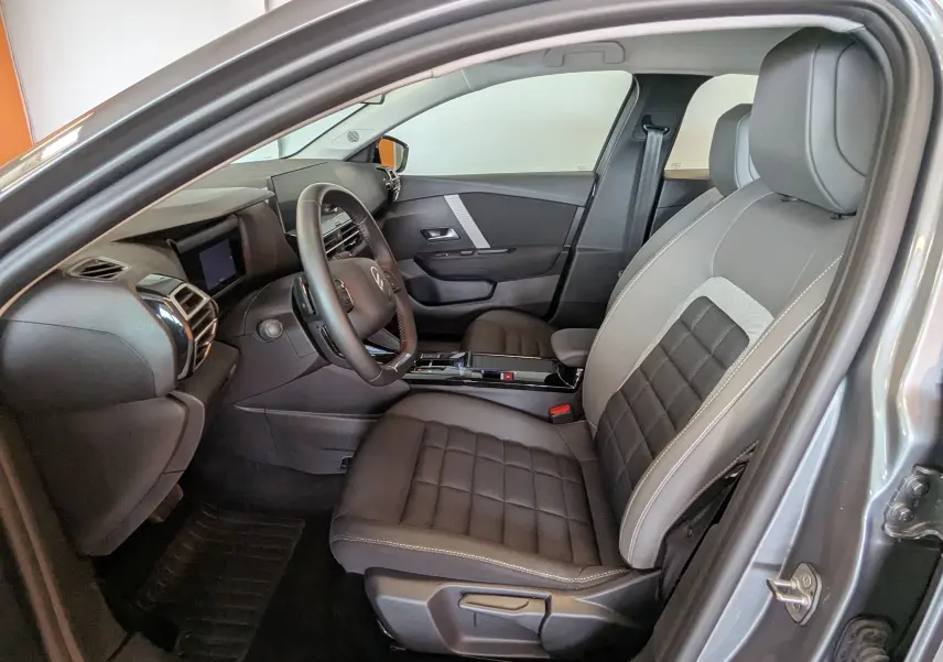 Intérieur côté conducteur d'une Citroën C4 Hybrid 145 gris Mercury, sièges tissu/TEP et tableau de bord moderne.