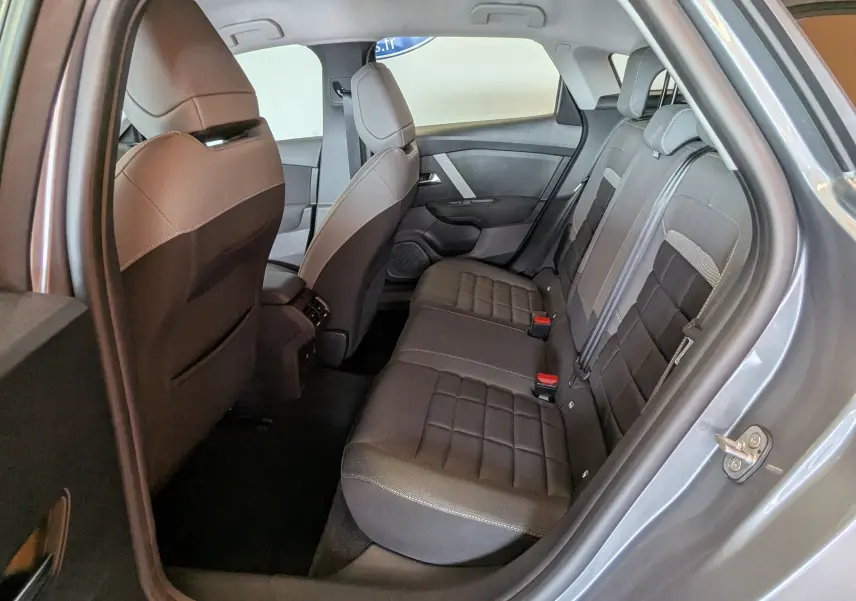 Vue intérieure arrière droite de la Citroën C4 Hybrid 145 gris Mercury, montrant les sièges tissu/TEP et les ceintures de sécurité.