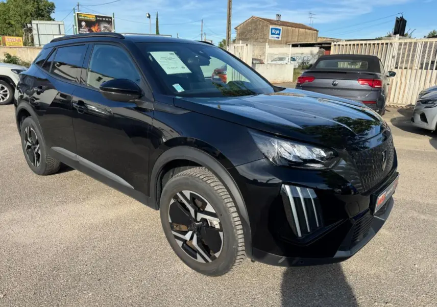 Peugeot 2008 Hybrid noir en 3/4 avant droit, avec barres de toit et jantes alliage 17 pouces visibles.