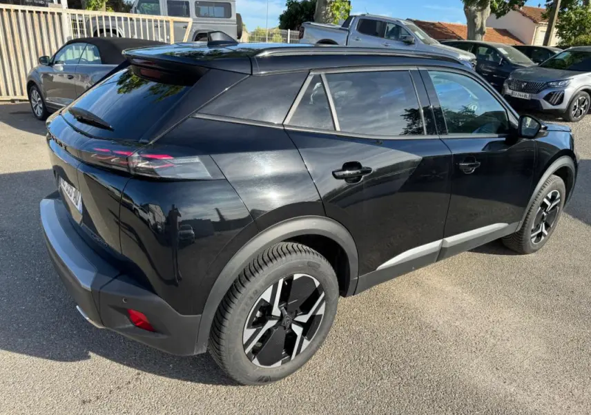 Peugeot 2008 Hybrid noir vue 3/4 arrière droit, avec barres de toit et jantes alliage 17 pouces.