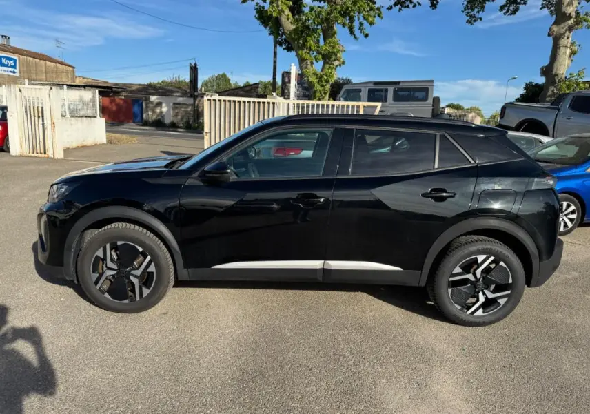 Peugeot 2008 Hybrid noir vu de profil côté gauche, avec barres de toit et jantes alliage 17 pouces.