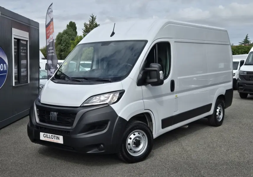 Fiat Ducato Fourgon blanc en 3/4 avant droit, avec pare-chocs noirs et calandre distinctive.