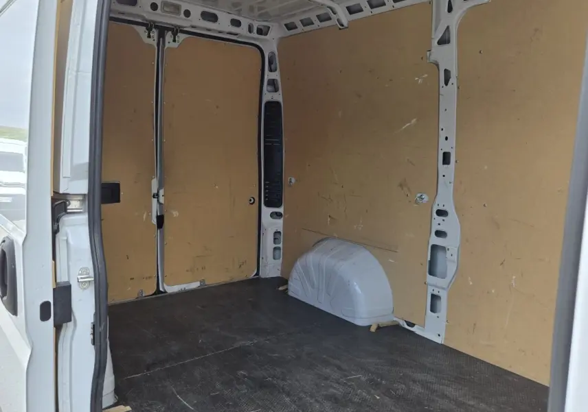 Vue intérieure arrière du fourgon blanc Fiat Ducato MH2 2023, montrant l'espace de chargement avec cloison pleine en bois.