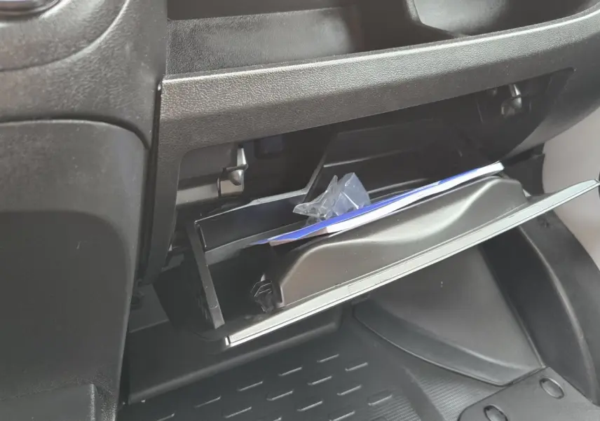 Vue rapprochée de la boîte à gants ouverte du Fiat Ducato Fourgon blanc, montrant l'intérieur et des documents.