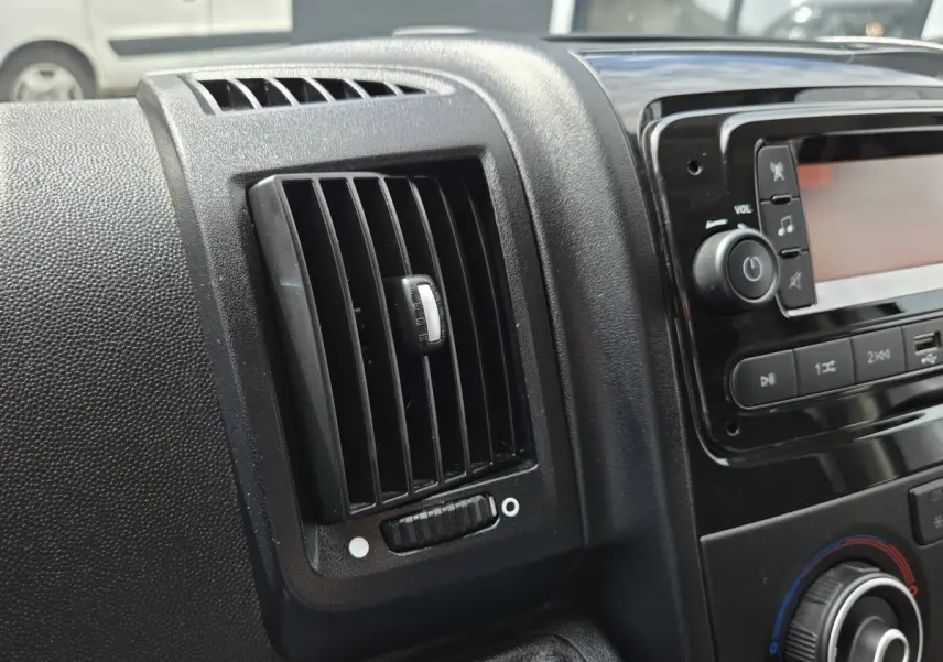 Détail de la ventilation et console centrale noire à l'intérieur du Fiat Ducato Fourgon blanc 2023.