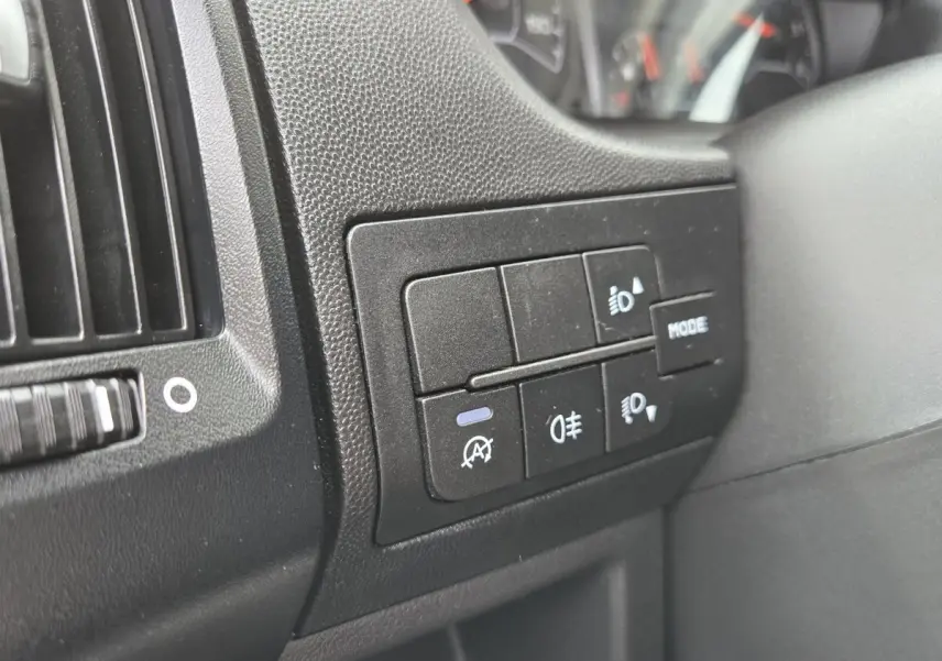 Détail des commandes d’éclairage et mode sur le tableau de bord noir du Fiat Ducato Fourgon 2023.