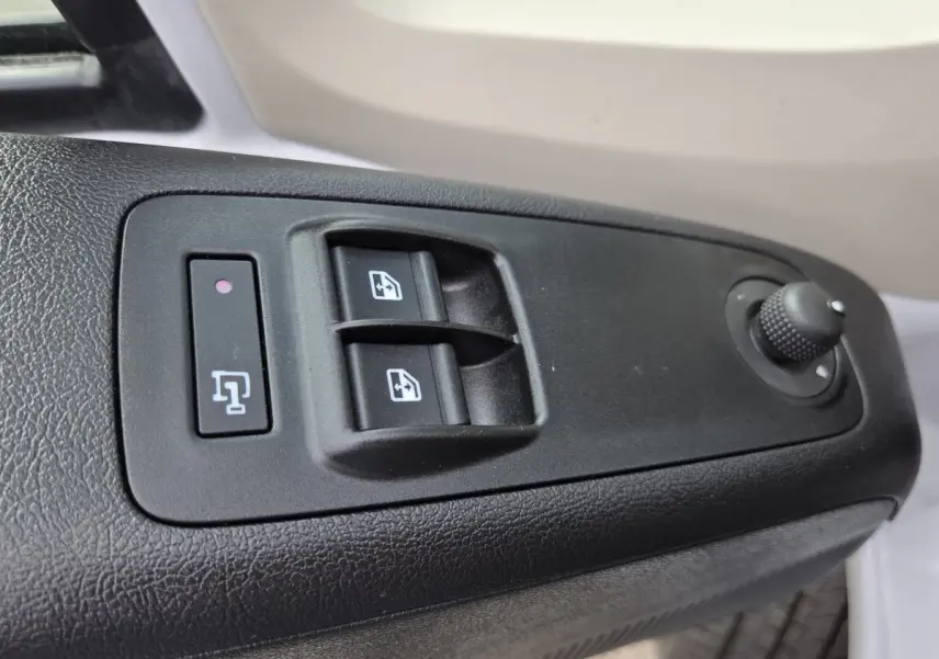 Gros plan sur les commandes de lève-vitres et réglage des rétroviseurs côté conducteur du Fiat Ducato Fourgon blanc.