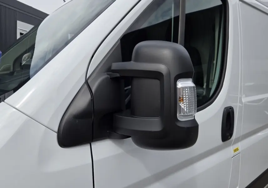 Gros plan sur le rétroviseur droit noir du FIAT Ducato Fourgon blanc, vue latérale avant du véhicule.