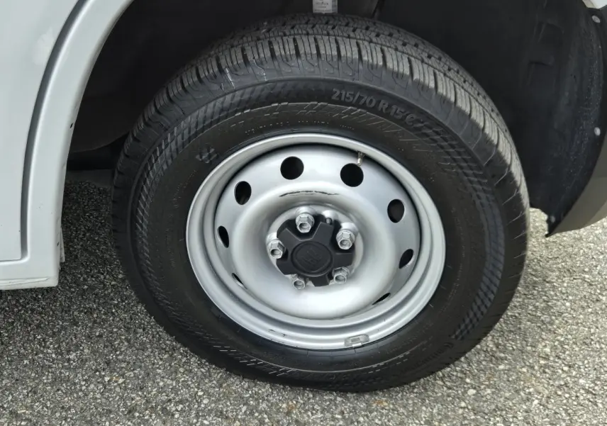 Gros plan sur la roue avant gauche du FIAT Ducato Fourgon blanc, mettant en valeur la jante acier et le pneu noir.