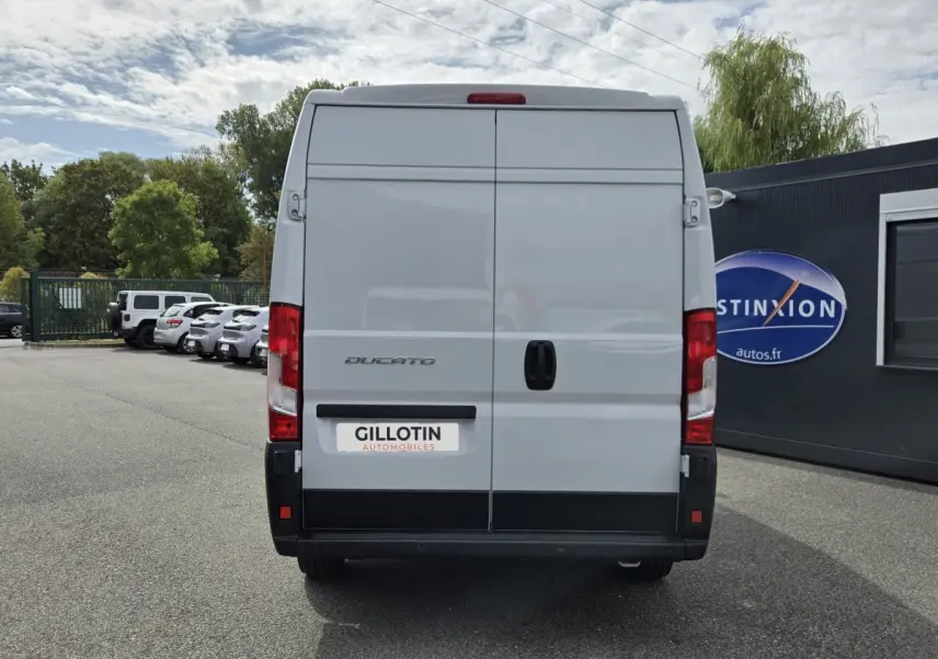 Vue arrière d’un FIAT Ducato Fourgon blanc 2023 avec portes arrière fermées et feux rouges visibles.