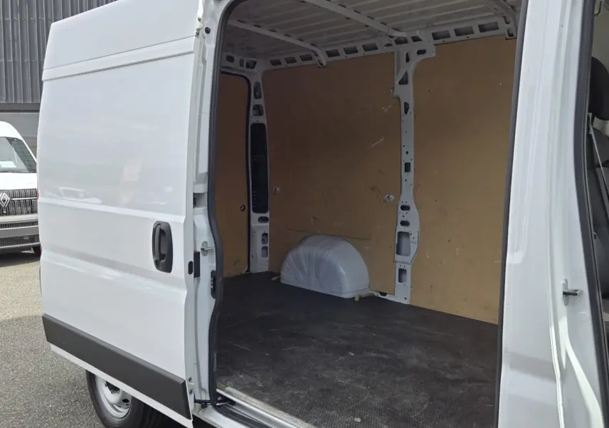 Fiat Ducato Fourgon blanc vu de côté gauche, porte coulissante ouverte montrant l’espace de chargement vide.