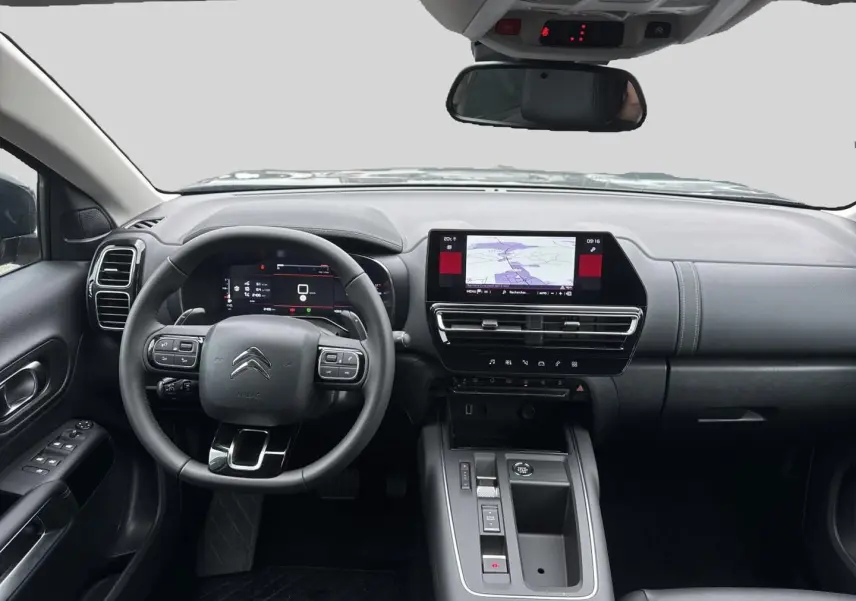 Vue intérieure avant du tableau de bord du Citroën C5 Aircross 2025, avec écran tactile et volant multifonction noir.