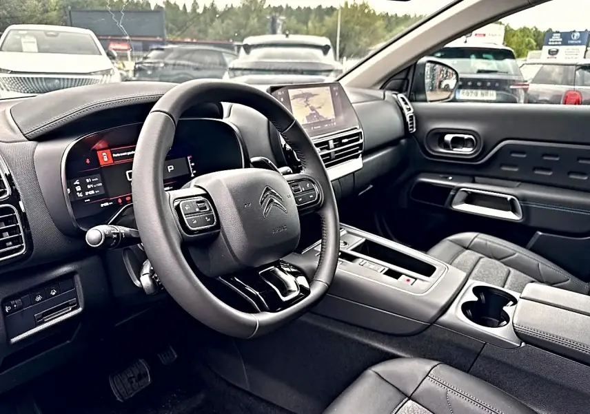 Vue intérieure côté conducteur du Citroën C5 Aircross 2025 avec volant cuir et écran tactile central.