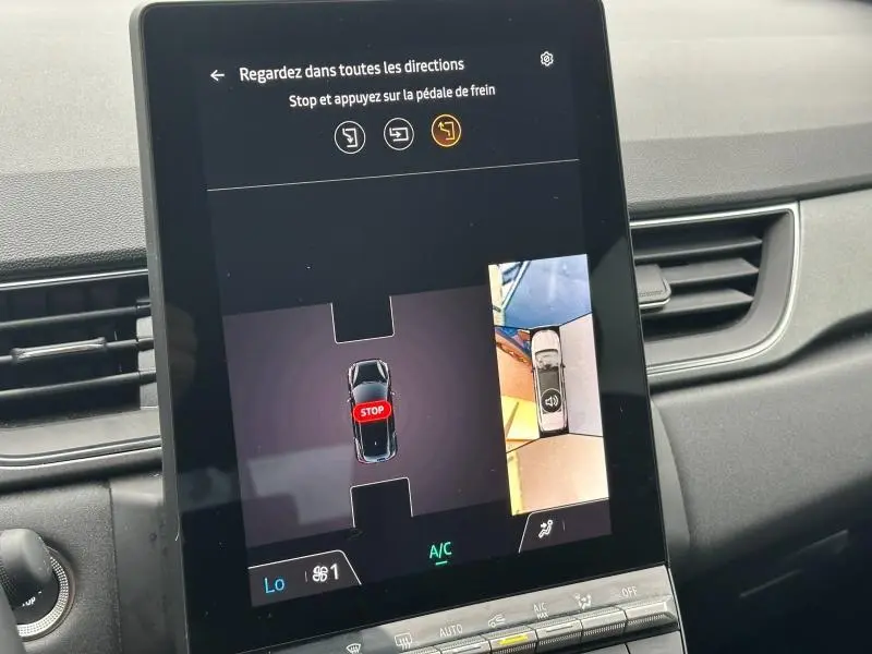 Écran tactile intérieur montrant la caméra de recul et l’aide au stationnement du Renault Captur 2025 bleu Iron/Noir Etoilé.