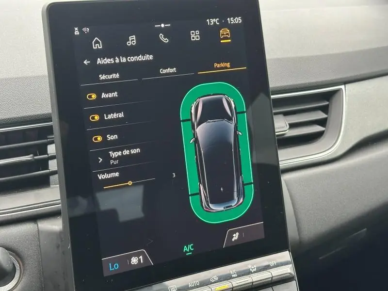 Écran tactile intérieur du Renault Captur 2025 affichant l'aide au stationnement avec vue du dessus du véhicule noir.