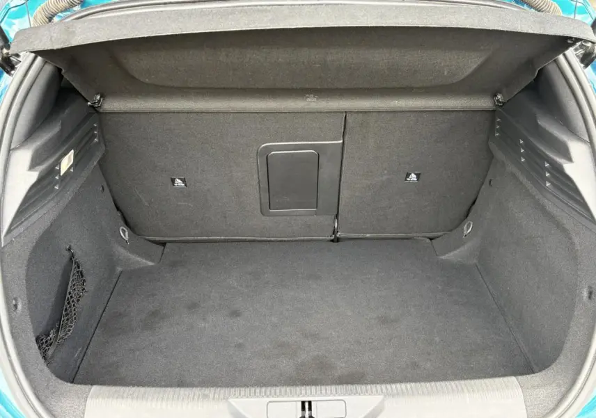 Coffre ouvert vu de l'arrière de la Peugeot 308 Bleu Obsession, montrant un espace de rangement propre et spacieux.