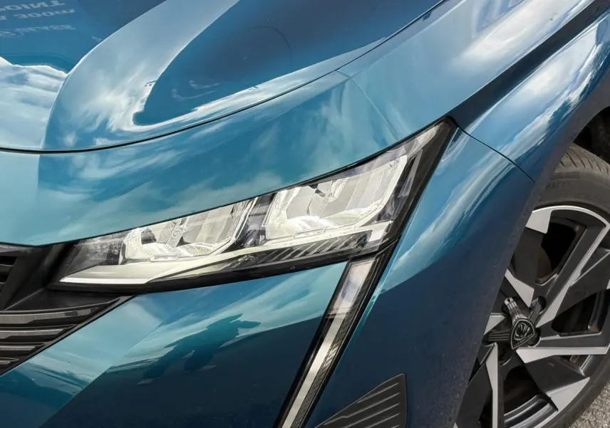 Gros plan sur l'avant droit bleu Obsession de la Peugeot 308 2024, avec phare LED et jante alliage 17 pouces.