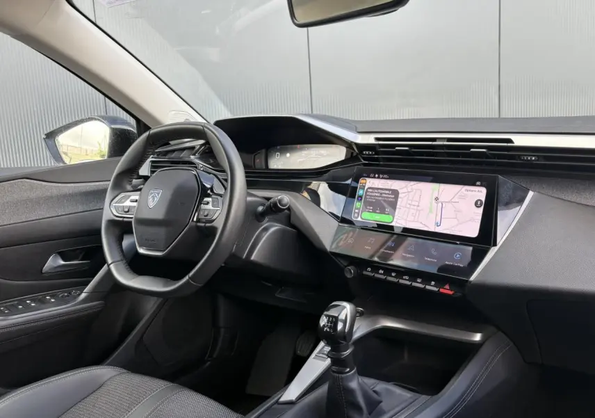 Vue intérieure avant gauche du Peugeot 308 2024 avec tableau de bord numérique et écran tactile 10 pouces.