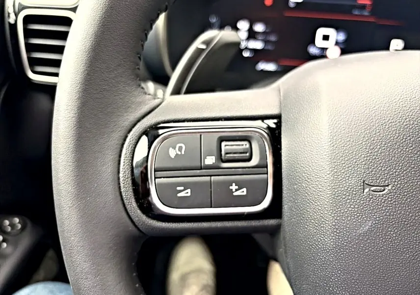 Gros plan sur les commandes au volant cuir noir du Citroën C5 Aircross 2025, côté gauche.